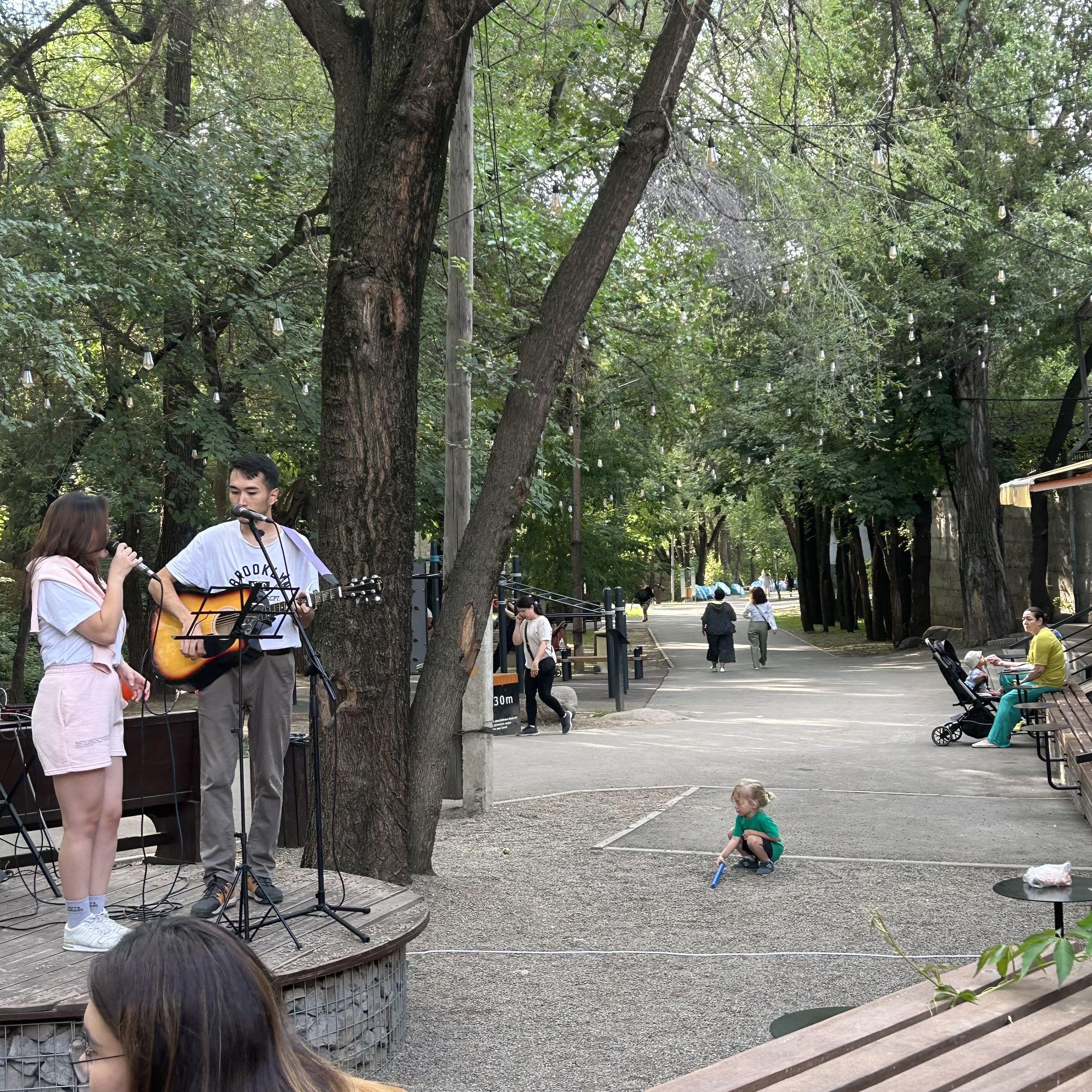 Buskers sing along a river path early on a summer evening