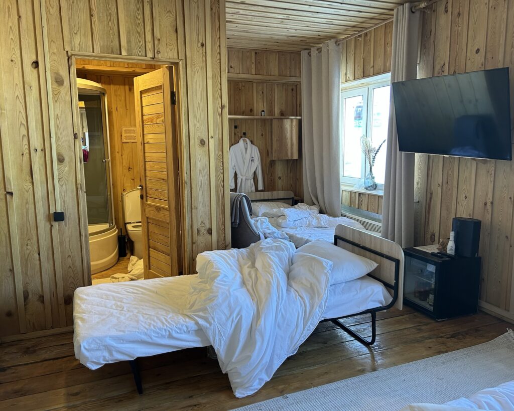 A hotel room at Le Mont Hotel with 2 trundle beds positioned outside a bathroom.