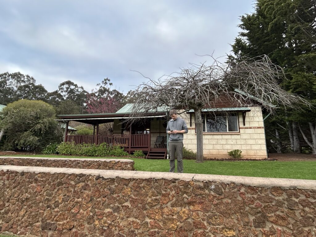 A man stands in front of a cottage at Clover Cottage Manjimup