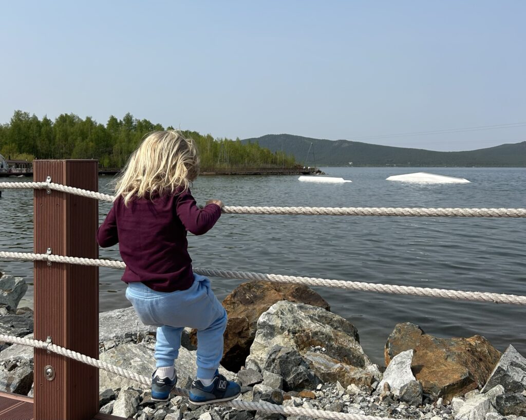 A photo of a boy climbing the rope fence in front of Lake Borovoye in Kazakhstan